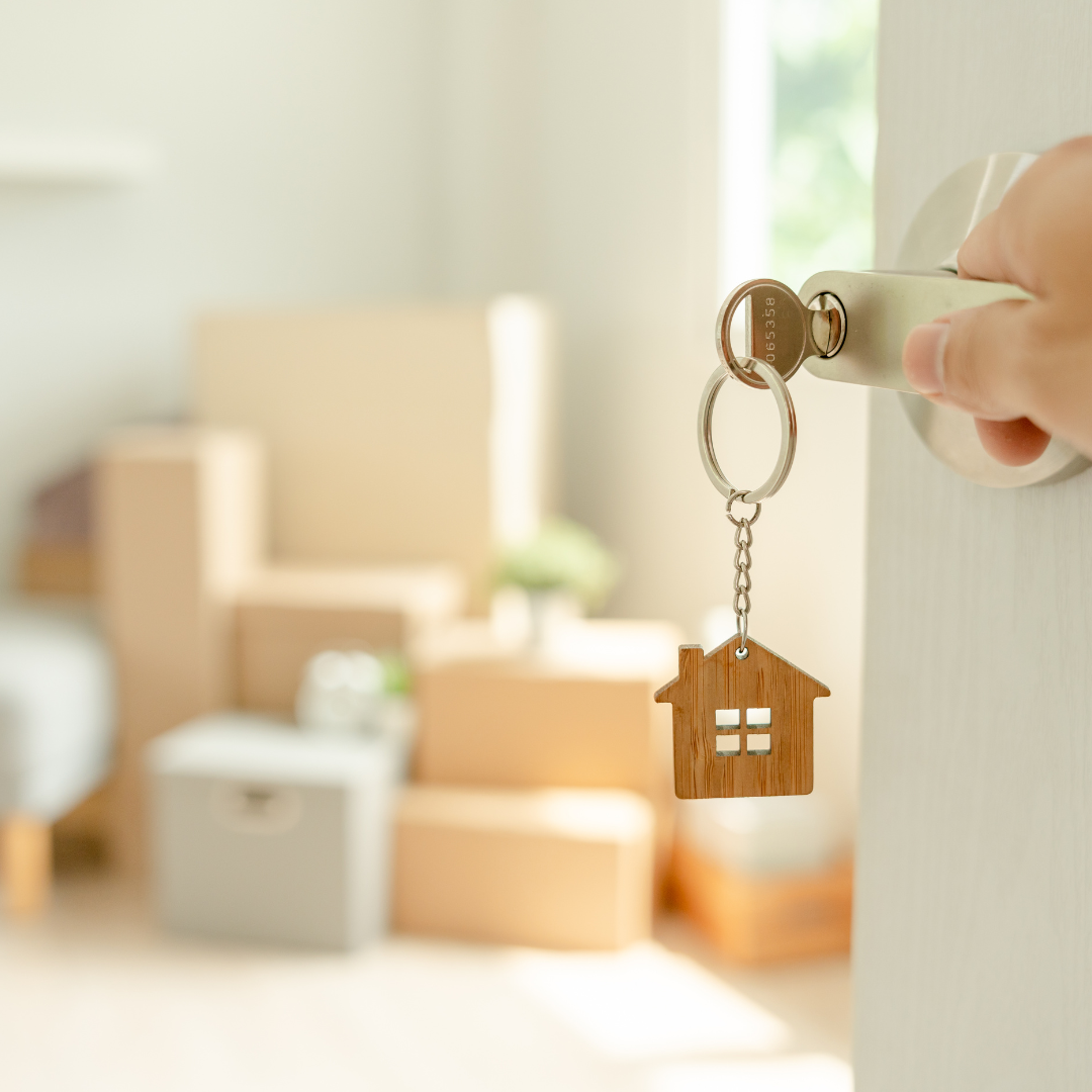 Keys to housing with moving boxes in background